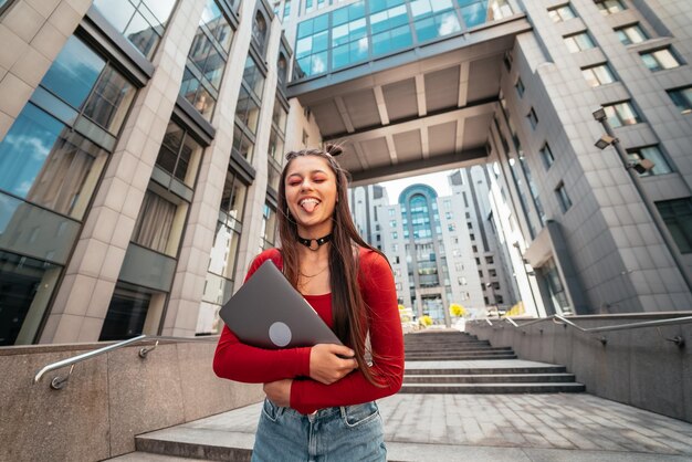 Jonge mooie vrouw met een laptop op straat