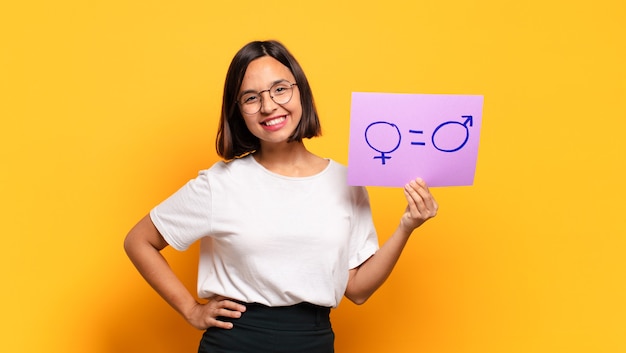 Jonge mooie vrouw met een papier met mannelijke en vrouwelijke teken. gelijkheidsconcept