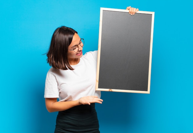 Jonge mooie vrouw met een schoolbord