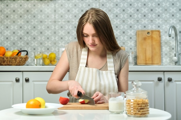 Jonge mooie vrouw met fruit in de keuken