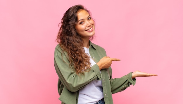 jonge mooie vrouw met groen denim open hemd poseren op roze muur