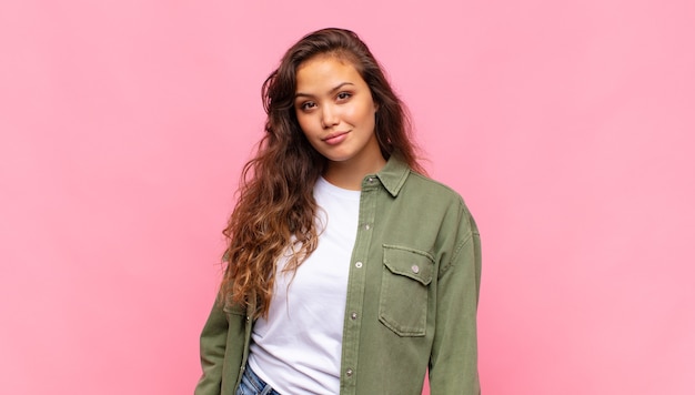 jonge mooie vrouw met groen denim open hemd poseren op roze muur