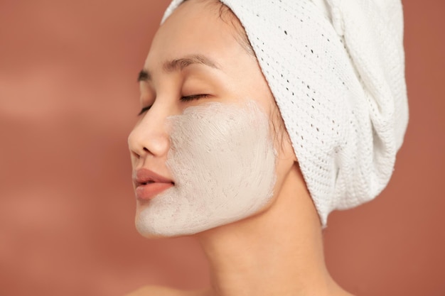 Jonge mooie vrouw met klei gezichtsmasker Spa behandeling zelfzorg en gezonde huid