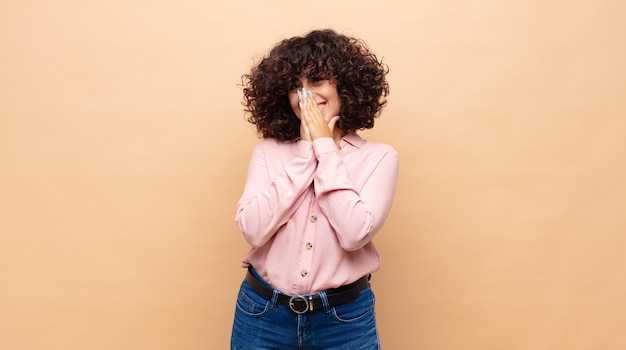 jonge mooie vrouw met krullend haar en een roze shirt