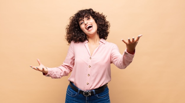 jonge mooie vrouw met krullend haar en een roze shirt