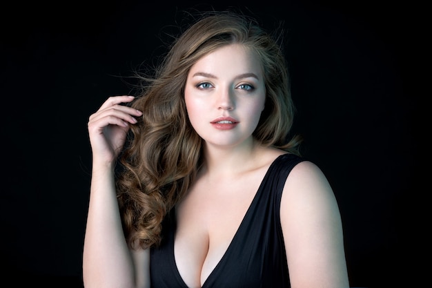 Jonge mooie vrouw met natuurlijke make-up op zwarte muur Schoonheid Huidverzorging Plus size model