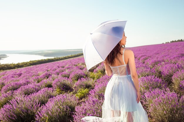 Jonge mooie vrouw met paraplu in een lavendelveld