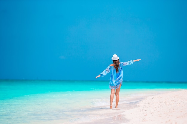 Jonge mooie vrouw met plezier op tropische kust. gelukkig meisje met blauwe lucht en turkoois water in de zee op het caribische eiland