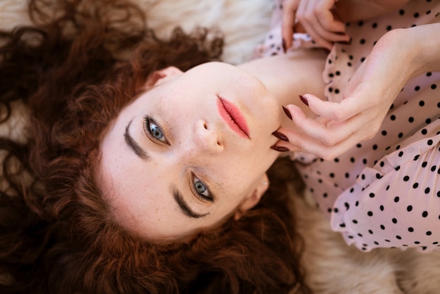 Jonge mooie vrouw met rood haar die op de vloer liggen