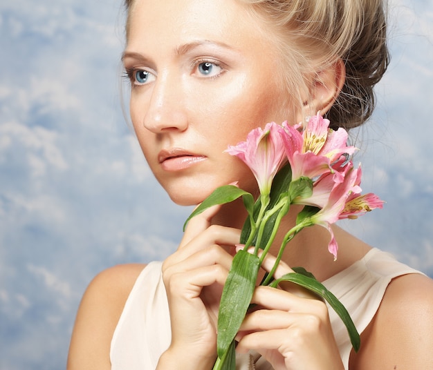 Foto jonge mooie vrouw met roze bloem