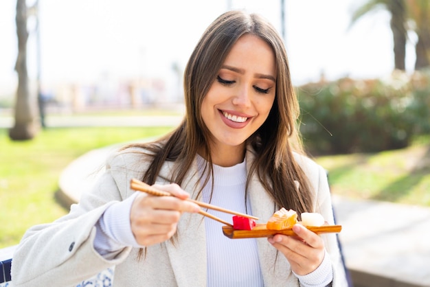 Jonge mooie vrouw met sashimi in de open lucht