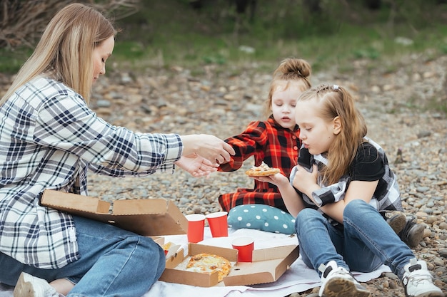 jonge mooie vrouw met twee kinderen op een picknick buiten de stad in het weekend