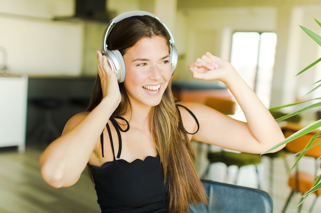 Jonge mooie vrouw muziek luisteren en dansen