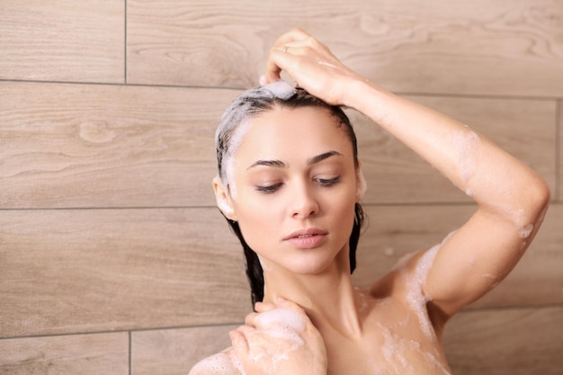 Jonge mooie vrouw onder de douche in de badkamer