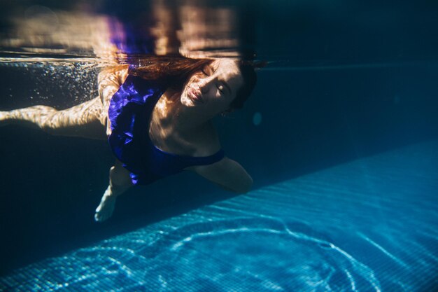 Jonge mooie vrouw onderwater zwemmenxA