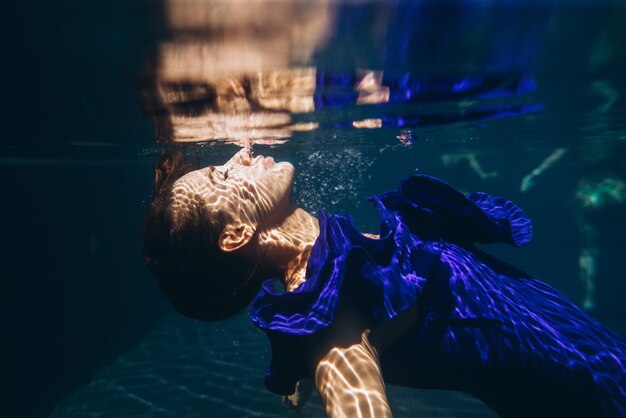 Foto jonge mooie vrouw onderwater zwemmenxa