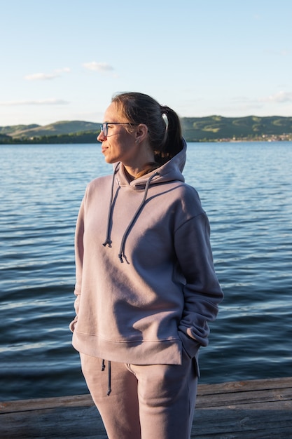 Jonge mooie vrouw op de pier zomer zonsondergang