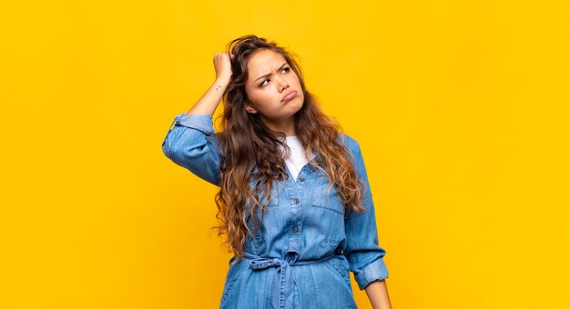 Jonge mooie vrouw op gele achtergrond