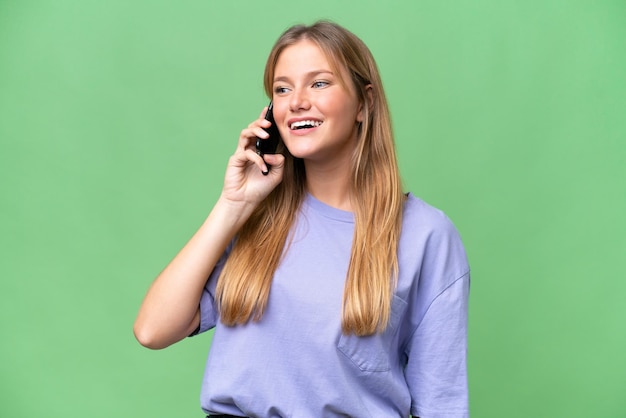 Jonge mooie vrouw over geïsoleerde achtergrond die een gesprek met de mobiele telefoon houdt