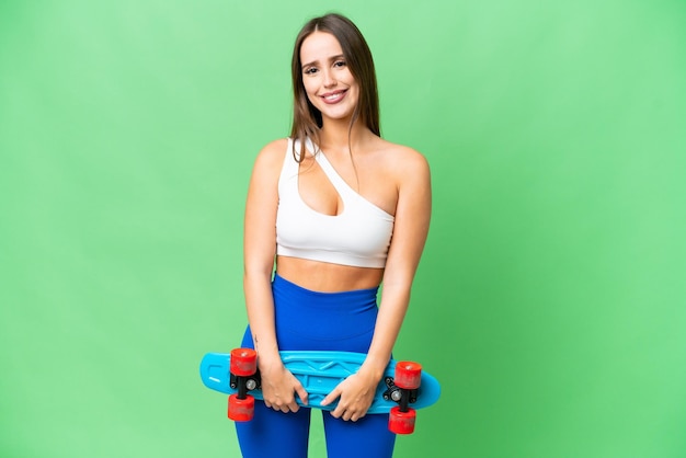 Jonge mooie vrouw over geïsoleerde chroma key achtergrond met een skate met een gelukkige uitdrukking