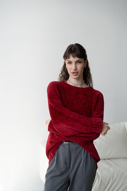 jonge mooie vrouw poseren in rode trui in studio