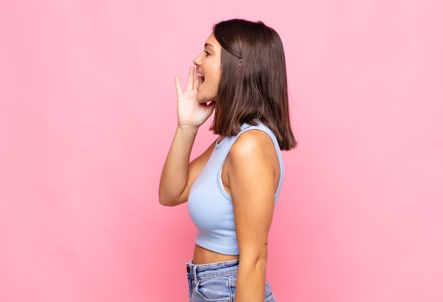 Jonge mooie vrouw profiel te bekijken, blij en opgewonden kijken, schreeuwen en bellen