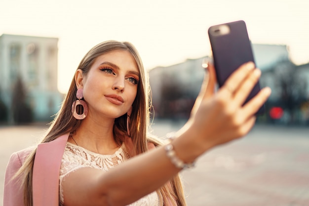 Jonge mooie vrouw selfie maken in de straat