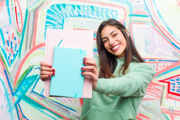 Jonge mooie vrouw tegen graffitimuur