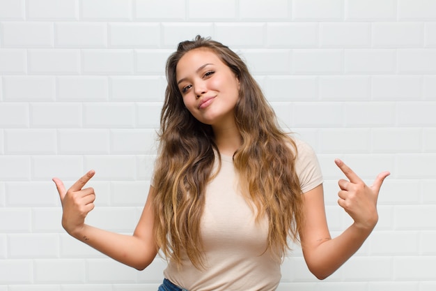 jonge mooie vrouw tegen witte muur