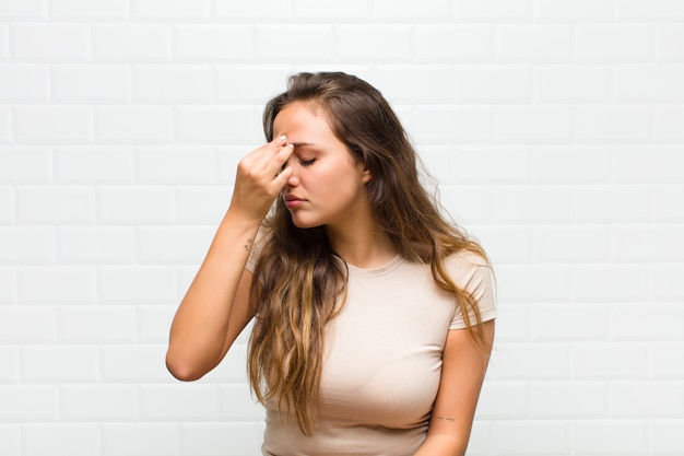 jonge mooie vrouw tegen witte muur