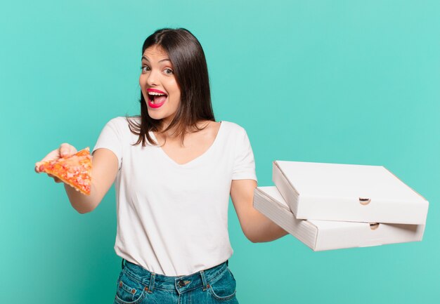 Jonge mooie vrouw verraste uitdrukking en houdt een pizza