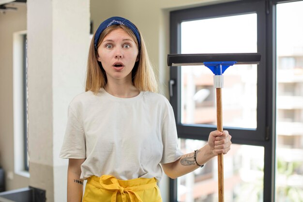 Foto jonge mooie vrouw voelt zich extreem geschokt en verrast windows washer-concept