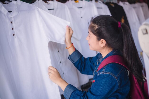 Jonge mooie vrouwen op zoek naar shirts tijdens reizen Dumnoen Saduak drijvende markt Thailand