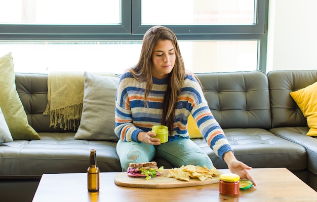 Jonge mooie vrouwenzitting op het eten van een leerbank