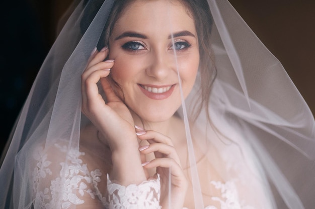 Jonge mooie zachte bruid in een witte kanten trouwjurk bedekt met een sluier Close-up weergave
