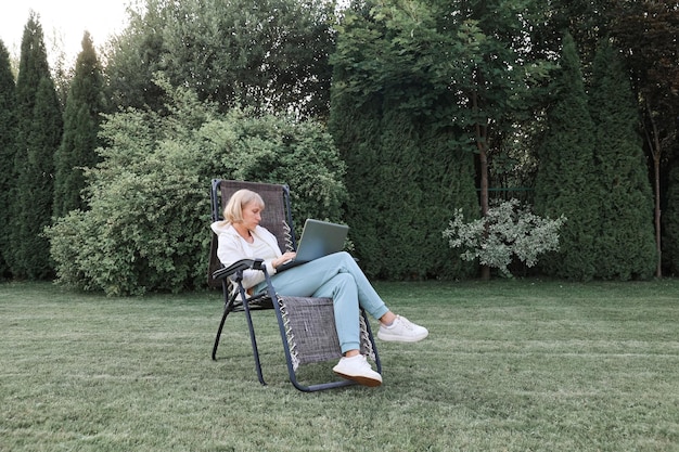 Jonge, mooie zakenvrouw die op een laptop werkt, freelancer werkt in de natuur Zakenvrouw op het werk buitenshuis