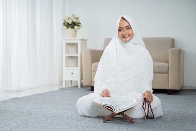 Jonge moslimvrouw bidden in witte traditionele kleding