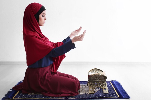 Jonge moslimvrouw die binnen bidt