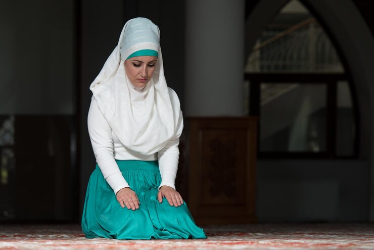 Foto jonge moslimvrouw die in moskee bidt