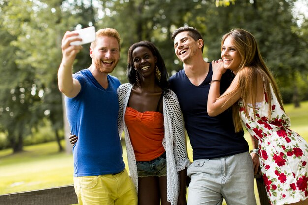 Jonge multiraciale vrienden die selfie in het park nemen