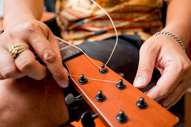 Jonge muzikant die snaren op een klassieke gitaar verandert in een gitaarwinkel