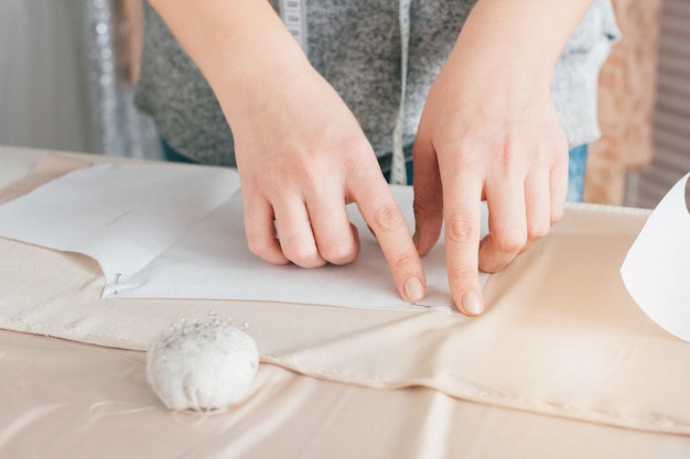 Jonge naaister maakt kleding stof snijden