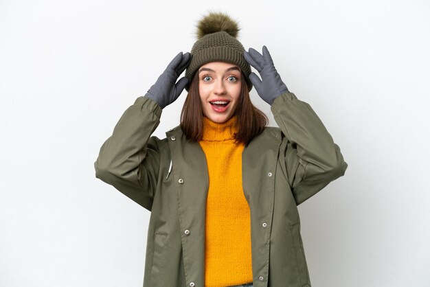 Foto jonge oekraïense vrouw die winterjas draagt die op witte achtergrond met verrassingsuitdrukking wordt geïsoleerd