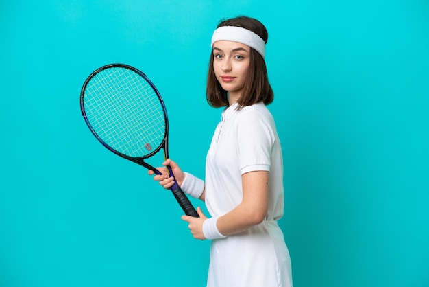 Jonge Oekraïense vrouw geïsoleerd op blauwe achtergrond tennissen