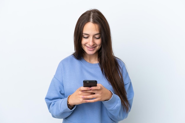 Jonge Oekraïense vrouw geïsoleerd op een witte achtergrond die een bericht of e-mail verzendt met de mobiel