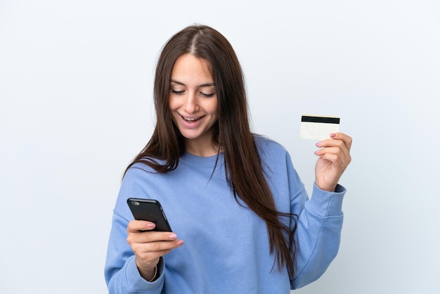 Jonge Oekraïense vrouw geïsoleerd op een witte achtergrond kopen met de mobiel met een creditcard