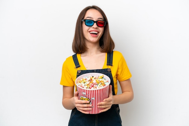 Jonge Oekraïense vrouw geïsoleerd op een witte achtergrond met 3D-bril en met een grote emmer popcorns