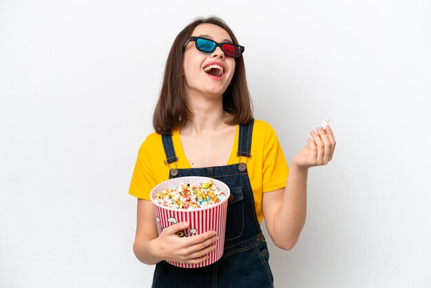 Jonge Oekraïense vrouw geïsoleerd op een witte achtergrond met 3D-bril en met een grote emmer popcorns