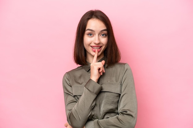 Jonge Oekraïense vrouw geïsoleerd op roze achtergrond met een teken van stilte gebaar vinger in mond