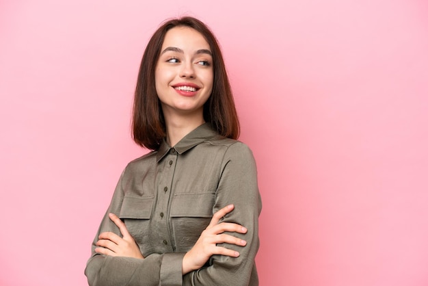 Jonge Oekraïense vrouw geïsoleerd op roze achtergrond met gekruiste armen en happy
